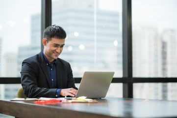 Young asian businessman working with laptop in office.