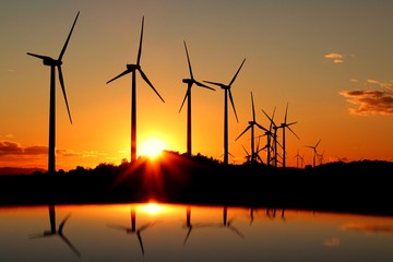 atardecer con reflejo con aerogenerador