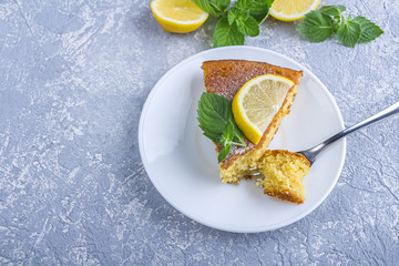 Step by step recipe. Cooking pie or semolina cake. Step 7 Piece of freshly baked pie or semolina cake on plate served lemon wedges and mint. Homemade food concept.
