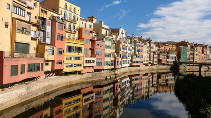 Fototapeta na wymiar Reflection of colourful houses on girona river