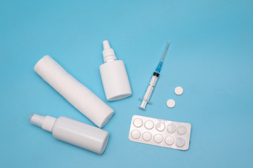 Nasal spray, pills, syringe, bandage injection on a blue background. Medicine concept.