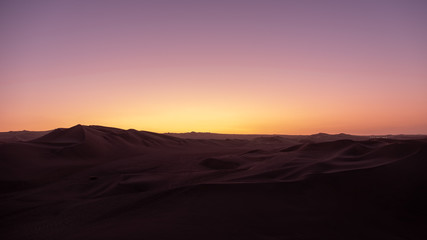 Fototapeta na wymiar Sunset over desert sand dunes