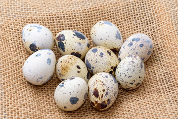 Obraz premium Quail eggs on top of a hemp fabric