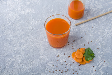 Nutritious detox carrot juice in glass with flaxed seeds and leaves of parsley. Alkaline diet concept. Organic vegetarian drink. Healthy eating. Still life, copy space for text