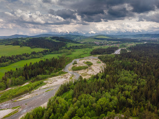 Fototapeta na wymiar Drone photo of Bialka River with view to the Tatra Mountains- spring season with pretty colours