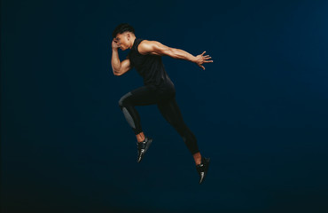 Obraz na płótnie Canvas Sportsman doing jumping and stretching workout.
