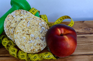 cereal fitness crisps dumbbells and tape measure on wooden background