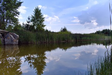 lake water surface with reflection of blue sky with clouds