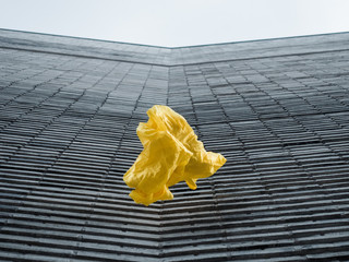 thrown yellow fabric in front of grey structured modern building