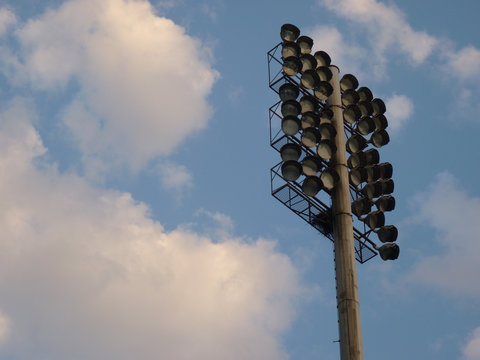 Low Angle Shot Of A Stadium Mast Lighting Against A Cloudy Blue Sky