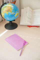 Homeschool. Back to school. Distance education. education concept with globe and books . Pink copybook for girl