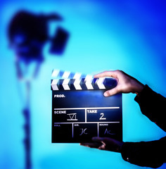 Hands showing clapperboard on filmset.