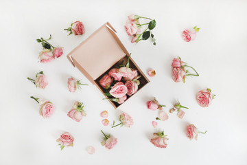 Craft gift box and flowers. Roses in a box with a floral background on white table. online shopping and fashion concept