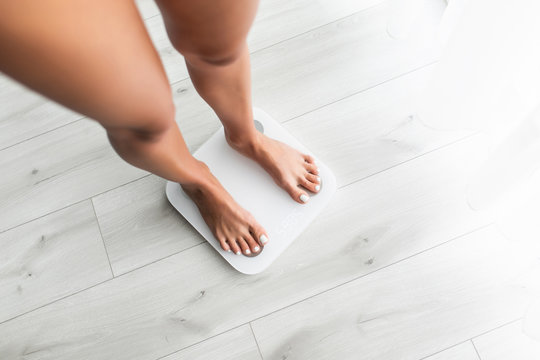 Feet Of Young Woman On Weighting Scale At Home