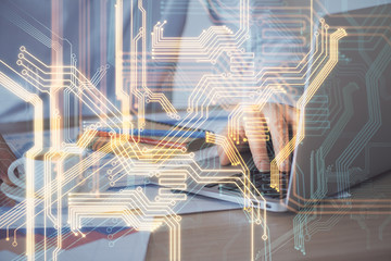 Technology theme hologram with man working on computer on background. High tech concept. Multi...