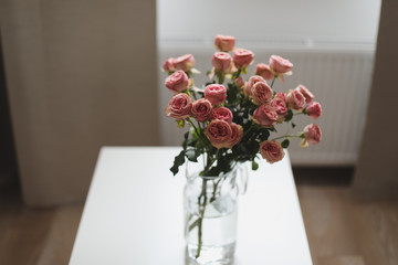 Cozy room with flowers in a vase on a table. Festive interior decoration. Living room decorated with flowers