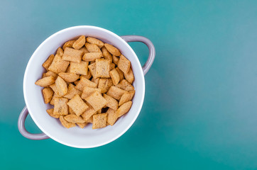Bowl with sweet corn pads with chocolate inside on a blue background, copy space, top view