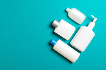 Set of White Cosmetic containers isolated on colored background, top view with copy space. Group of plastic bodycare bottle containers with empty space for you design