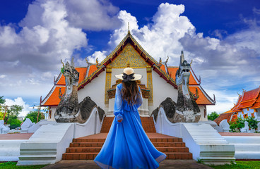 Asian female tourist wearing a blue dress visits Phumin Temple in Nan province, Thailand.