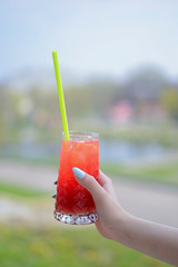 Hand holding smoothie shake cocktail. Drinking red healthy smoothie concept. Seasonal cocktail.