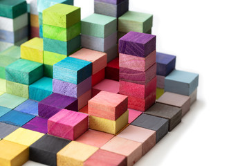 Spectrum of stacked multi-colored wooden blocks. Background or cover for something creative, diverse, expanding, rising or growing. On pure white.