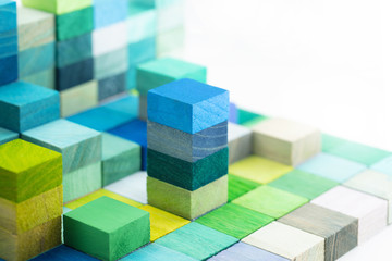 Fototapeta na wymiar Spectrum of stacked multi-colored wooden blocks. Background or cover for something creative, diverse, expanding, rising or growing. Shallow depth of field.