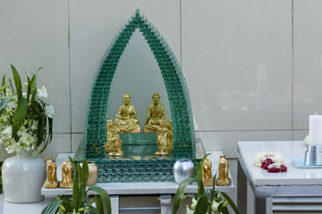 Spirit house in glass with a statue of Phra Phrom, representation of Brahma, the Hindu god of creation in Bangkok, Thailand