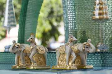 Glass spirit house with marble horses and elephant in Bangkok, Thailand