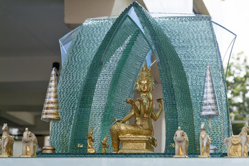 Spirit house in glass with a statue of Phra Phrom, representation of Brahma, the Hindu god of creation in Bangkok, Thailand