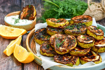 Home made  organic fried zucchini with  garlic yogurt sauce on wooden background