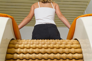 young girl making massage for leg femur. Roll Massage machine is a way to shape the figure. Skin...