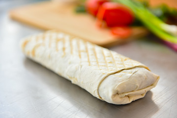 kebab meat with vegetables on a wheat tortilla