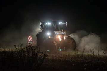 Traktor bestellt ein Feld in der Nacht