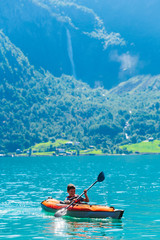 Boy are sea kayaking in Norwegian fjord 
