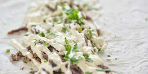 kebab meat with vegetables on a wheat tortilla