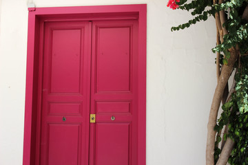 Pink door closed in a white wall