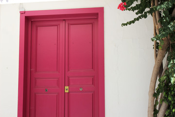 Pink door closed in a white wall