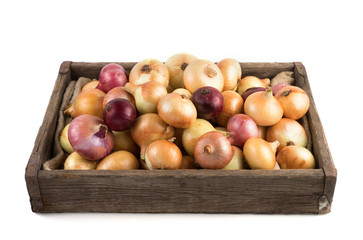 Yellow and red onions in a rustic wooden box isolated on a white background, side view. Full frame. Vegetable background. Concept of food, farm products.