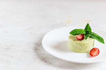 Homemade avocado panna cotta with strawberries and mint in a white plate. Sugar, lactose, gluten...