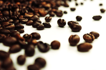 roasted coffee beans are in pile isolated on white,can be used as background or texture. Roasted coffee beans using special technique in which sugars, starches and fats are emulsified into coffee oil