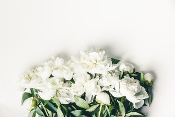 Flat-lay of Beautiful peony flowers over white background, top view, copy space