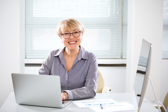 Portrait of mature business woman looking at camera in an office