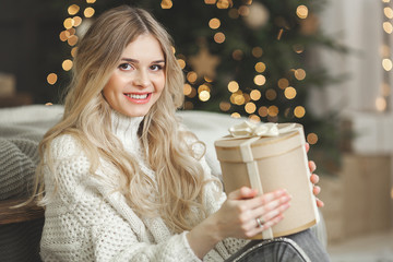 Closeup portrait of attractive blond young woman on christmas background
