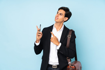 Businessman over isolated blue background pointing with the index finger a great idea