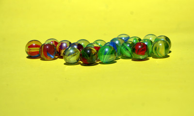 colored marble isolated in yellow background