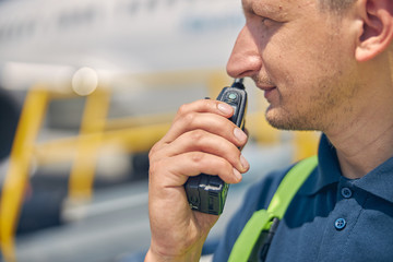 Man using a two-way radio transceiver outside