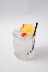 Vodka with ice and canned cherries decorated with an orange slice.
