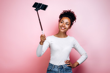 Pretty, smiling girl taking a selfie with a selfie stick