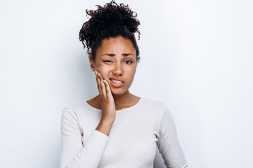 Fototapeta na wymiar African american girl standing over isolated white background touching mouth with hand with painful expression because of toothache