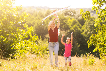 Fototapeta na wymiar Young woman and girl flying a kite